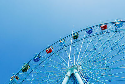 Low angle view of ferris wheel against clear blue sky