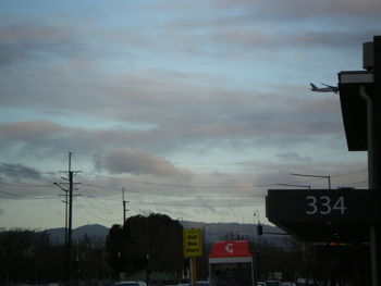 Road sign against cloudy sky