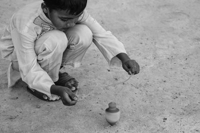 Full length of boy playing with spinning top