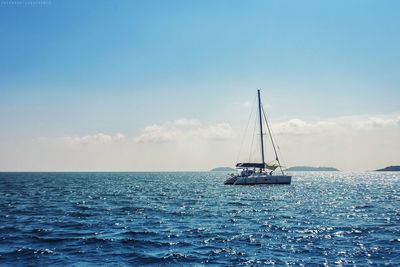 Sailboat sailing on sea against sky