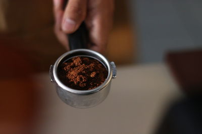 Close-up of hand holding coffee cup