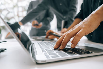 Midsection of man using mobile phone on table