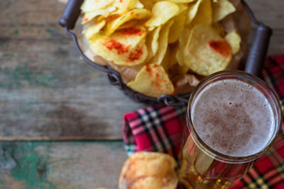 High angle view of potato chips by beer on table