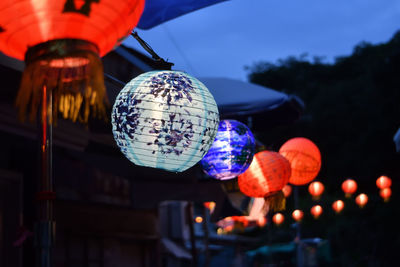 Low angle view of illuminated lanterns hanging at night