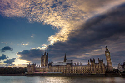 City at waterfront against dramatic sky