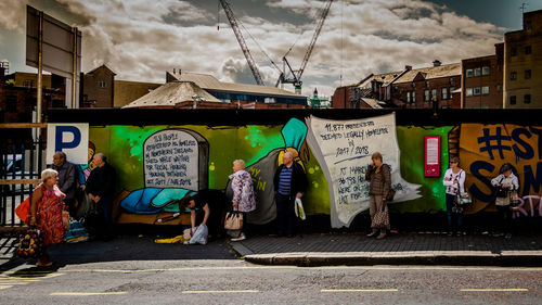 People on street in city against sky