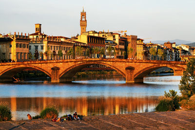 Ponte alla carraia over arno river by residential buildings against sky