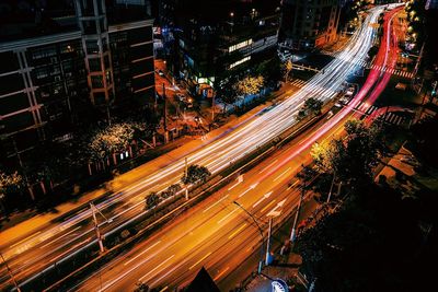 High angle view of light trails on street by building at night