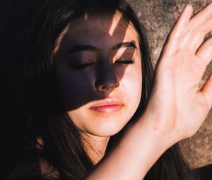 Close-up of girl shielding closed eyes