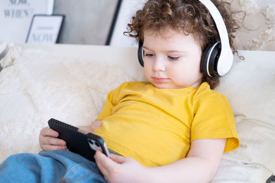 Portrait of boy listening music on smart phone
