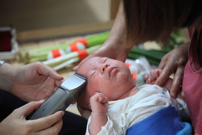 Man trimming baby hair through electric razor