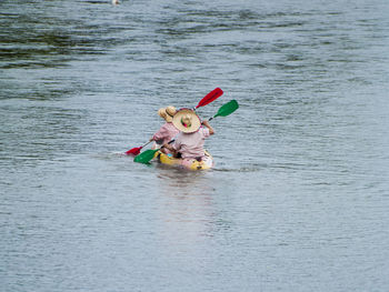 People rowing boat on river