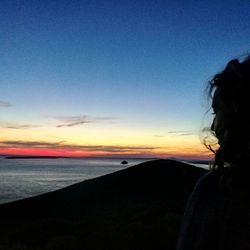 Silhouette woman by sea against clear sky during sunset