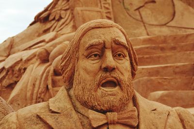 Low angle view of a sand statue of pavarotti