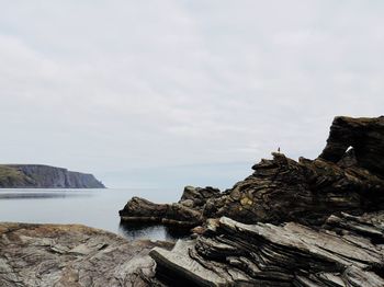 Rock formations by sea against sky