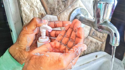 Close-up of hand holding glass of water
