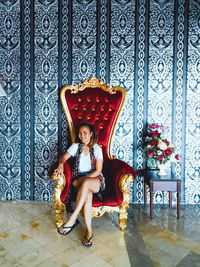 Full length portrait of woman sitting on chair