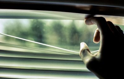 Close-up of man looking through window