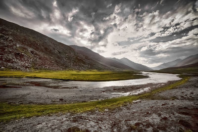 Scenic view of lake by mountains against sky