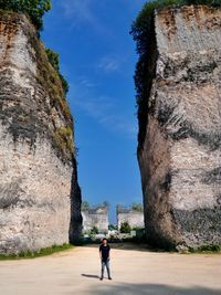 Mid distance view of man standing against rock formations at garuda wisnu kencana