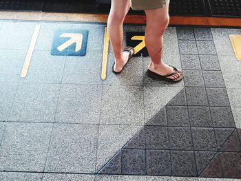 Low section of woman walking on railroad station platform