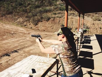 Side view young woman holding gun