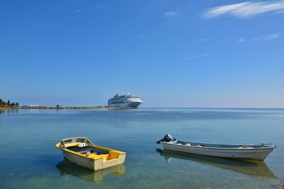 Ship moored on sea against blue sky