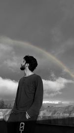 Rear view of person standing on rainbow against sky