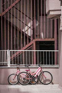 Pair of two pink retro bicycles on geometric background of stairs