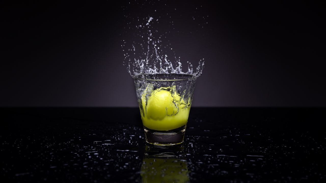 drink, refreshment, food and drink, glass, drinking glass, indoors, household equipment, studio shot, splashing, alcohol, no people, close-up, table, freshness, food, motion, black background, still life, fruit