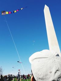 Low angle view of balloons flying against blue sky