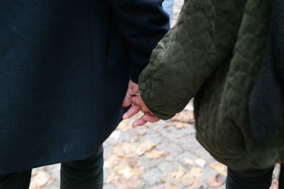 Midsection of couple holding hands