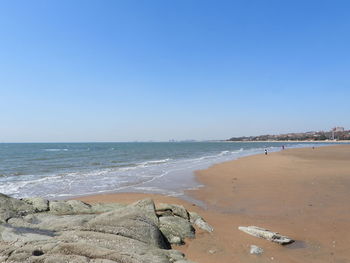 Scenic view of beach against clear blue sky