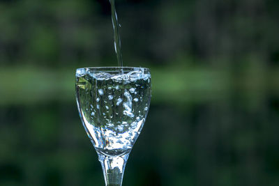 Water pouring in wineglass