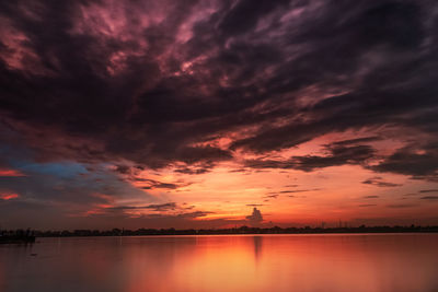 Scenic view of dramatic sky over lake during sunset