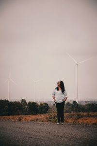 Full length of woman standing on field against sky