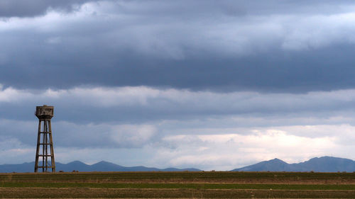 Storage tank on land against sky