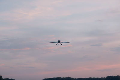Low angle view of silhouette airplane against sky during sunset