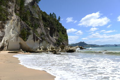 Rock formation on beach against sky