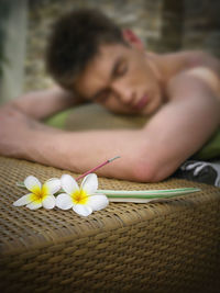 Shirtless man lying on poolside