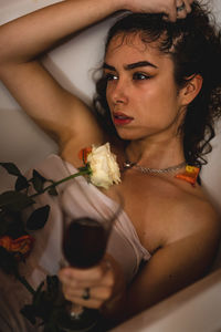Young woman holding flower and wine glass