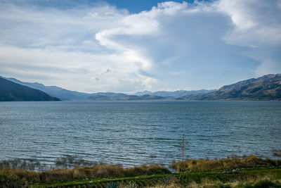 Lagoon near mountains and cloudy sky