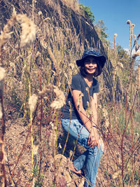 Portrait of smiling woman standing by plants