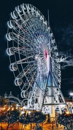 Low angle view of illuminated ferris wheel against sky at night