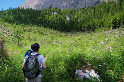 Rear view of man and woman on tree in forest