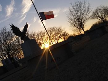 Low angle view of silhouette flag against sky during sunset