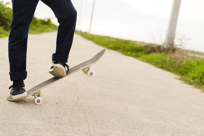 Low section of man skateboarding on footpath