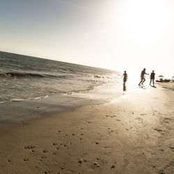 People on beach against sky