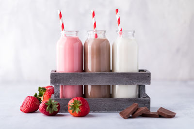 Three glass bottles of neapolitan flavoured milk.