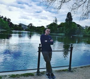 Man standing by lake against sky